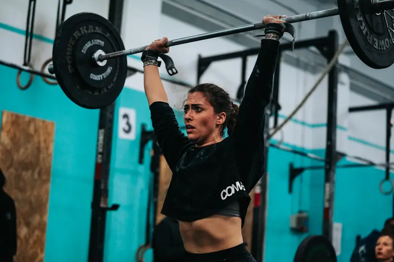 Atleta sosteniendo la barra sobre la cabeza en un snatch
